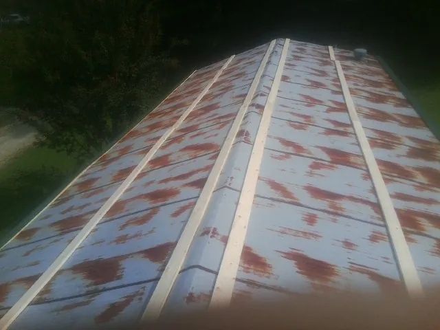 Rusted metal roof panels with new wood purlins before replacement — Storm Damage Roof Repair in Wellfleet by Roofing Brothers