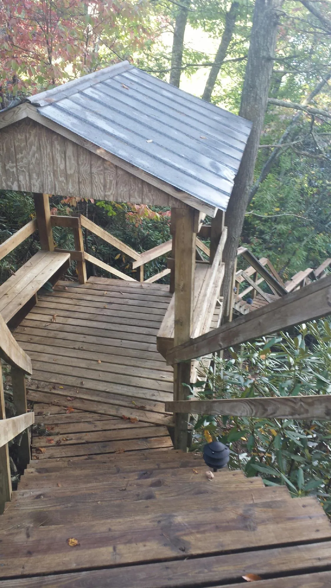 Metal roofed shelter over wooden steps on a wooded walkway — Skylight Repair & Installation work by our crew in Wellfleet