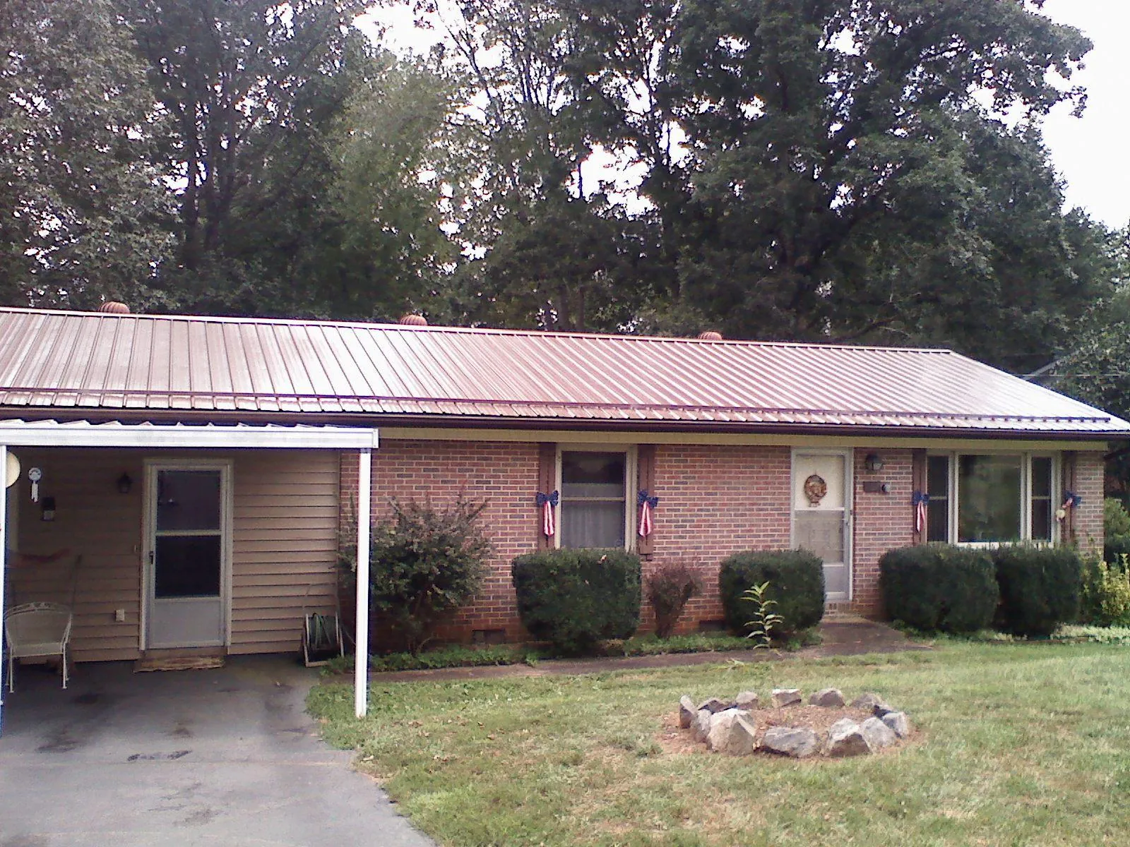 Bronze metal roof and carport on a brick ranch home — Roof Repair work by our crew in Wellfleet